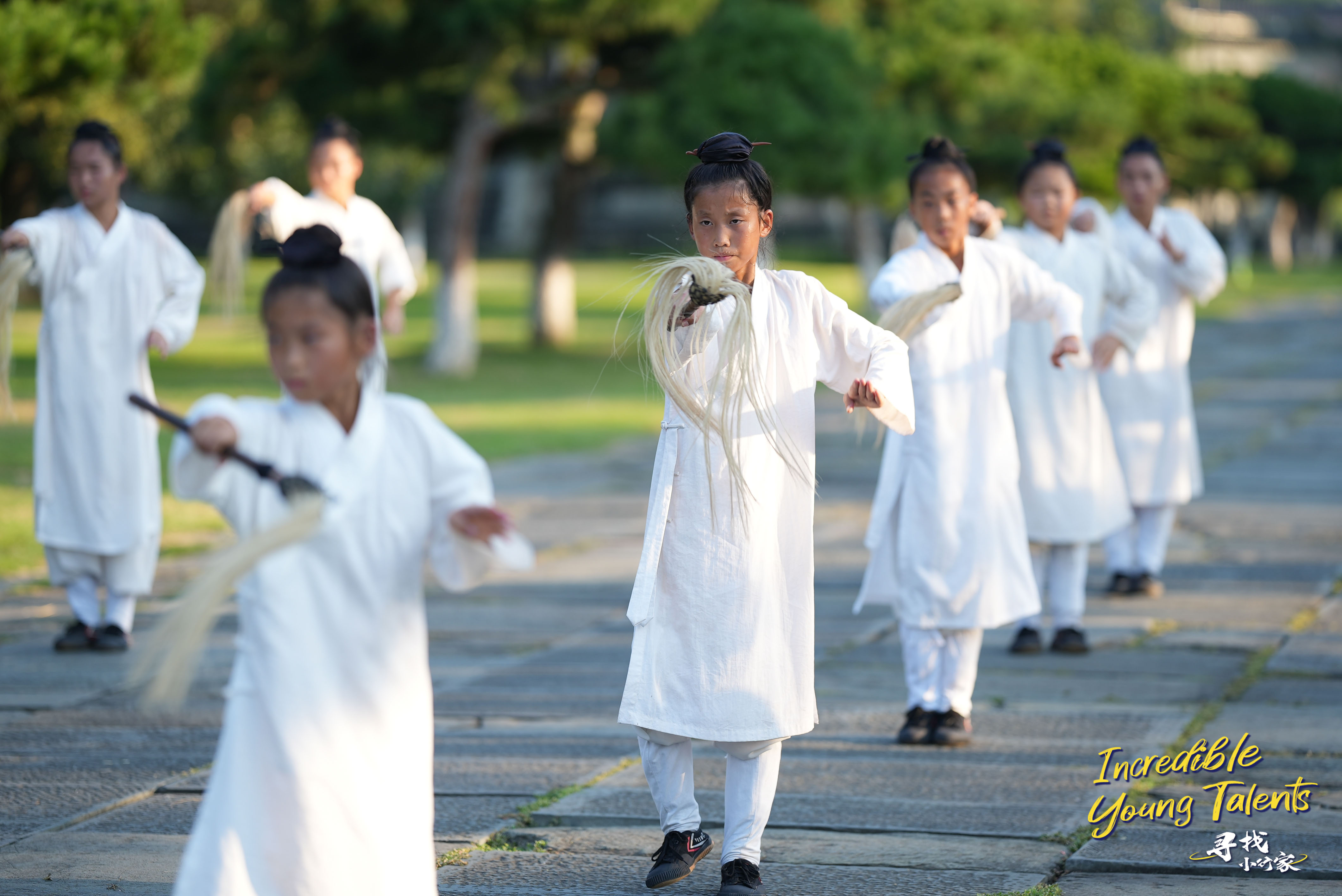 Young students of a martial art school practice horsetail whisk routines in the Wudang Mountains. /CGTN