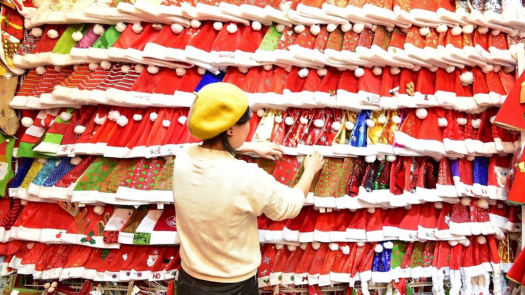 File photo of a shop keeper stands before Christmas hats in Yiwu International Trade City, east China's Zhejiang Province. /CFP