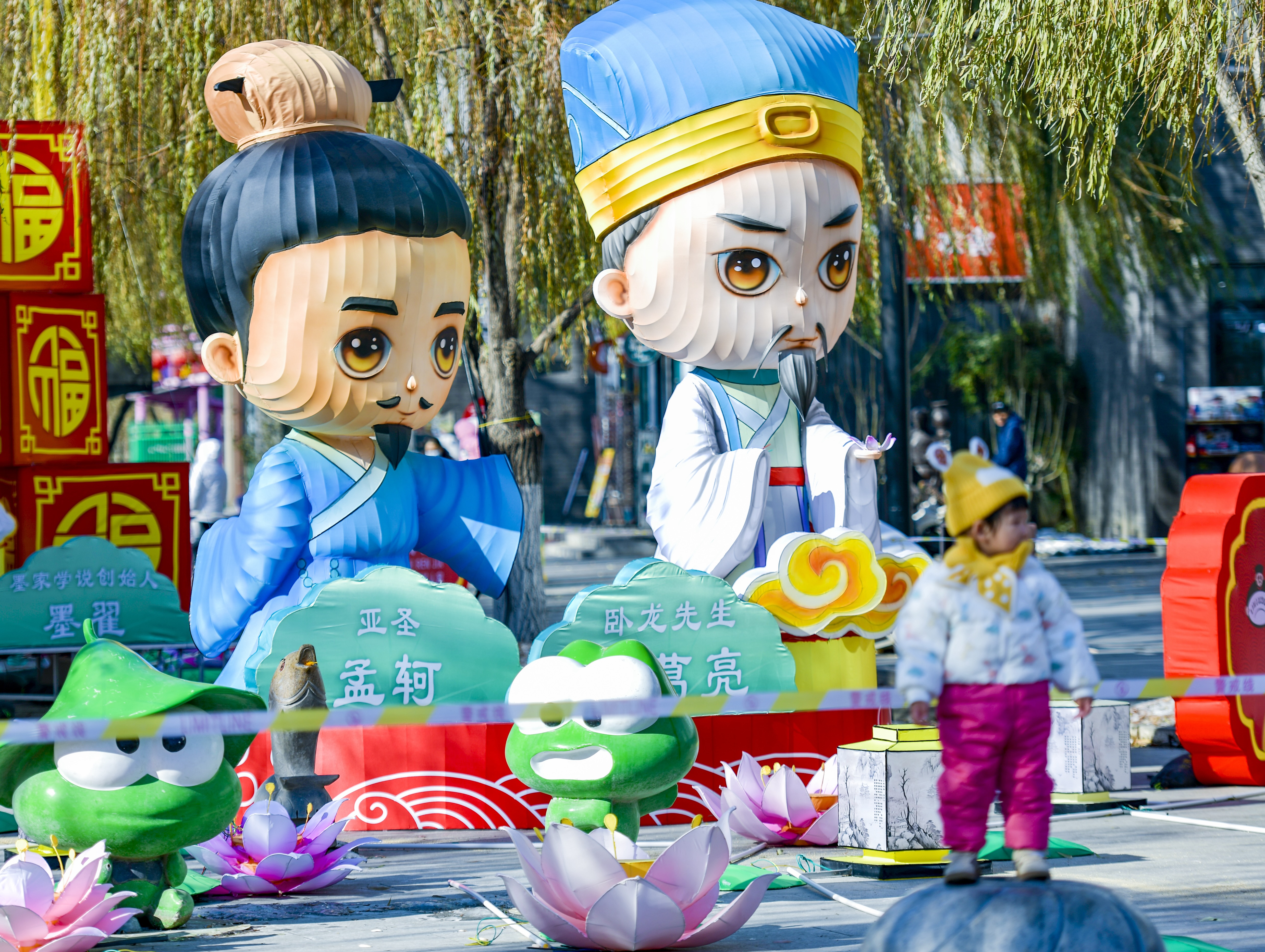 A child poses in front of festive lanterns of ancient Chinese thinkers at 