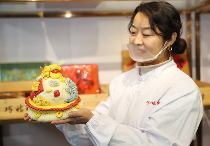 A chef showcases traditional Shandong huabobo at a kitchen in Qingdao City, Shandong Province, December 24, 2023. /CFP