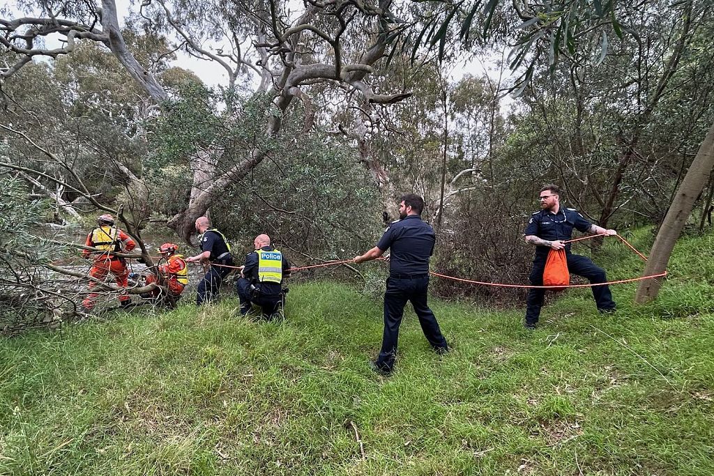Emergency workers rescue a woman from flood waters after heavy rain in the east of Melbourne, Australia, December 27, 2023. /CFP