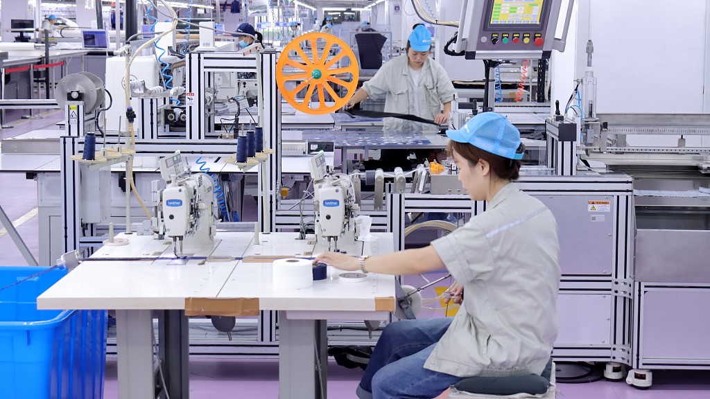 2023年10月11日，中国东部江苏省一家纺织公司的工人在操作机器。/CFP