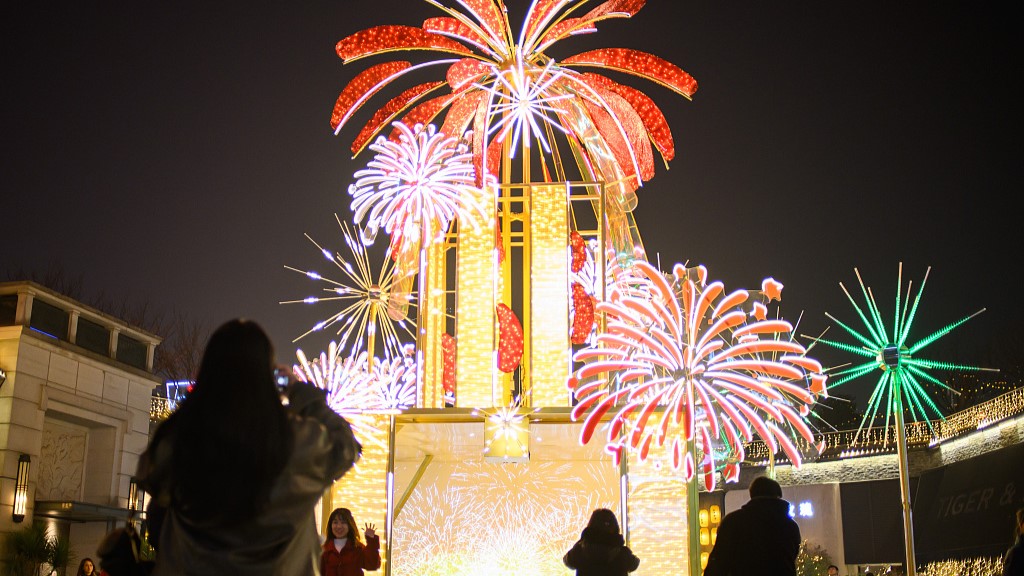 Visitors take photos in front of a New Year display in southwest China's Chongqing, December 26, 2023. /CFP