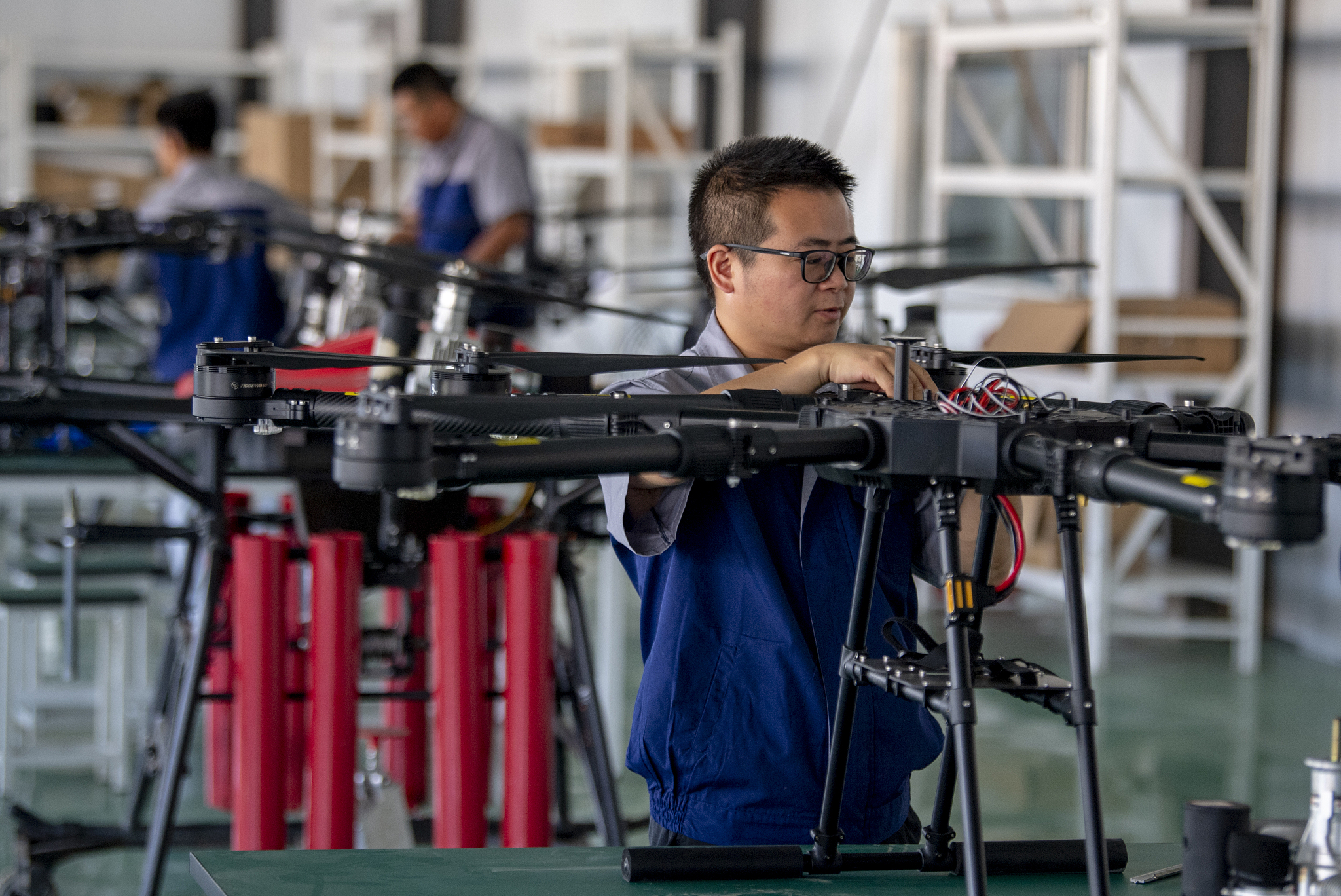 Workers assemble oil-powered drones. /VCG