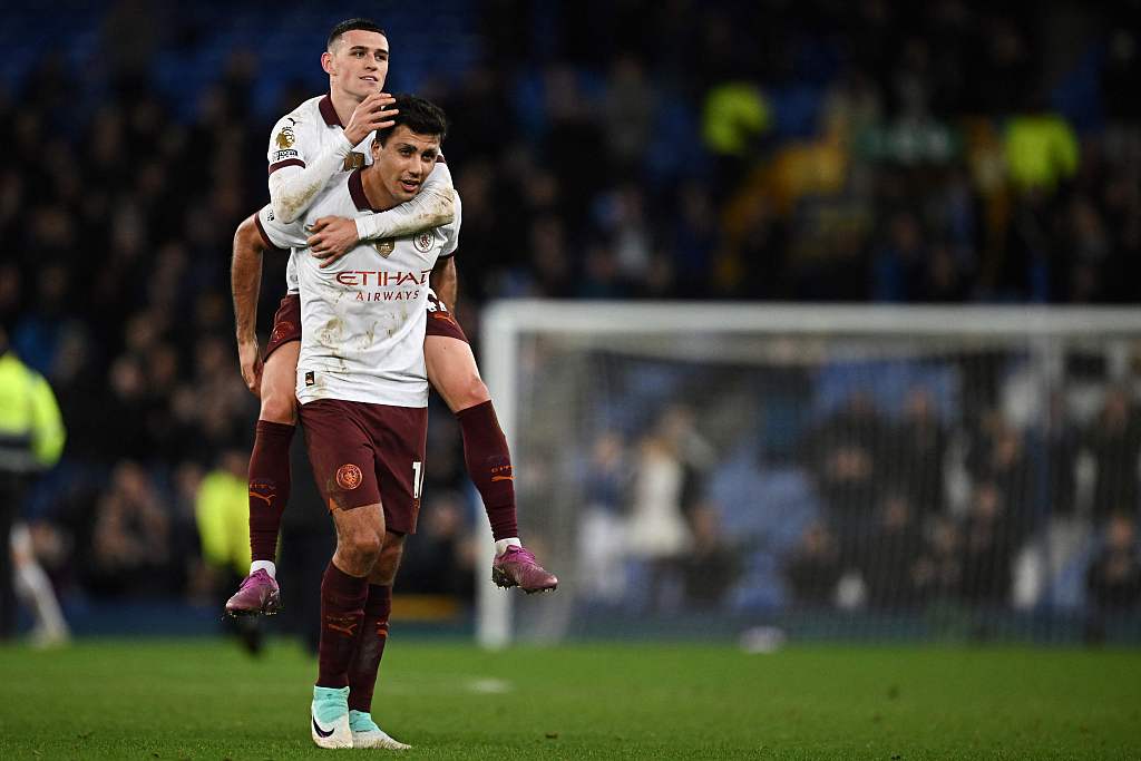 Manchester City's Phil Foden jumps on Rodri's back to celebrate his equalizer during their Premier League clash with Everton at Goodison Park in Liverpool, England, December 27, 2023. /CFP