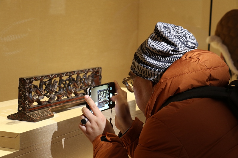 A visitor takes photos of intricate lacquer art at the Liangzhu Museum in Hangzhou City, Zhejiang Province, on December 27, 2023. /CFP