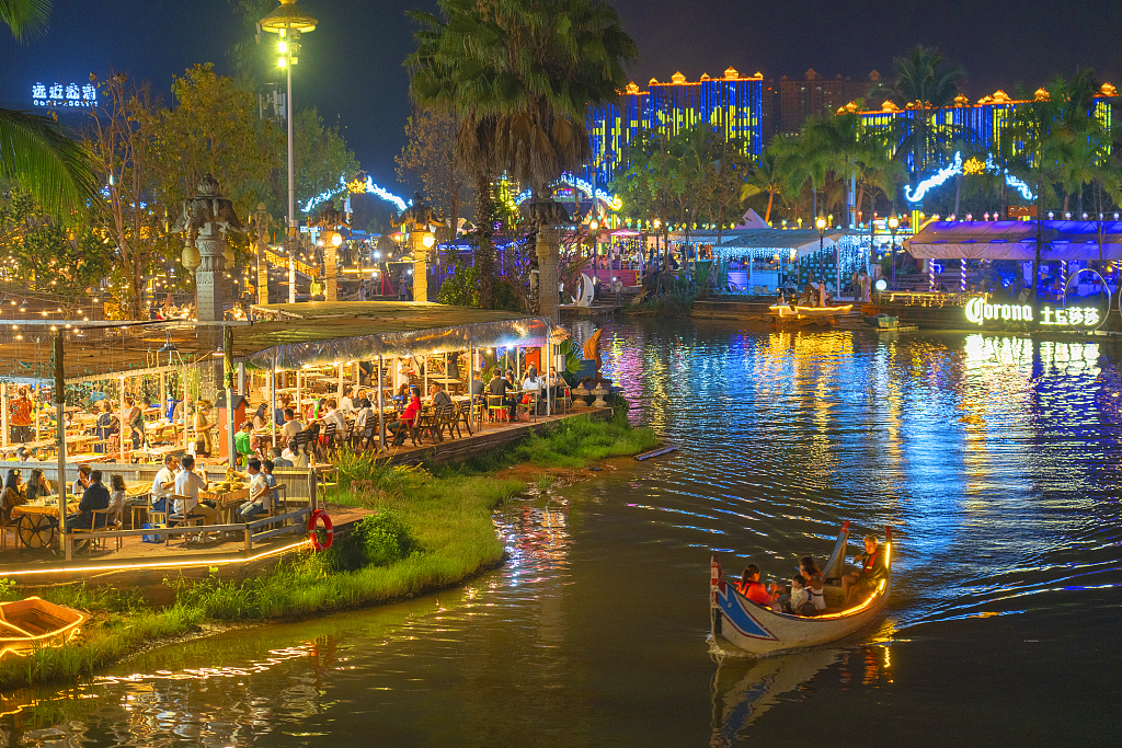 People dine and enjoy the night view along the Lancang River in Xishuangbanna, southwest China's Yunnan Province, March 4, 2023. /CFP