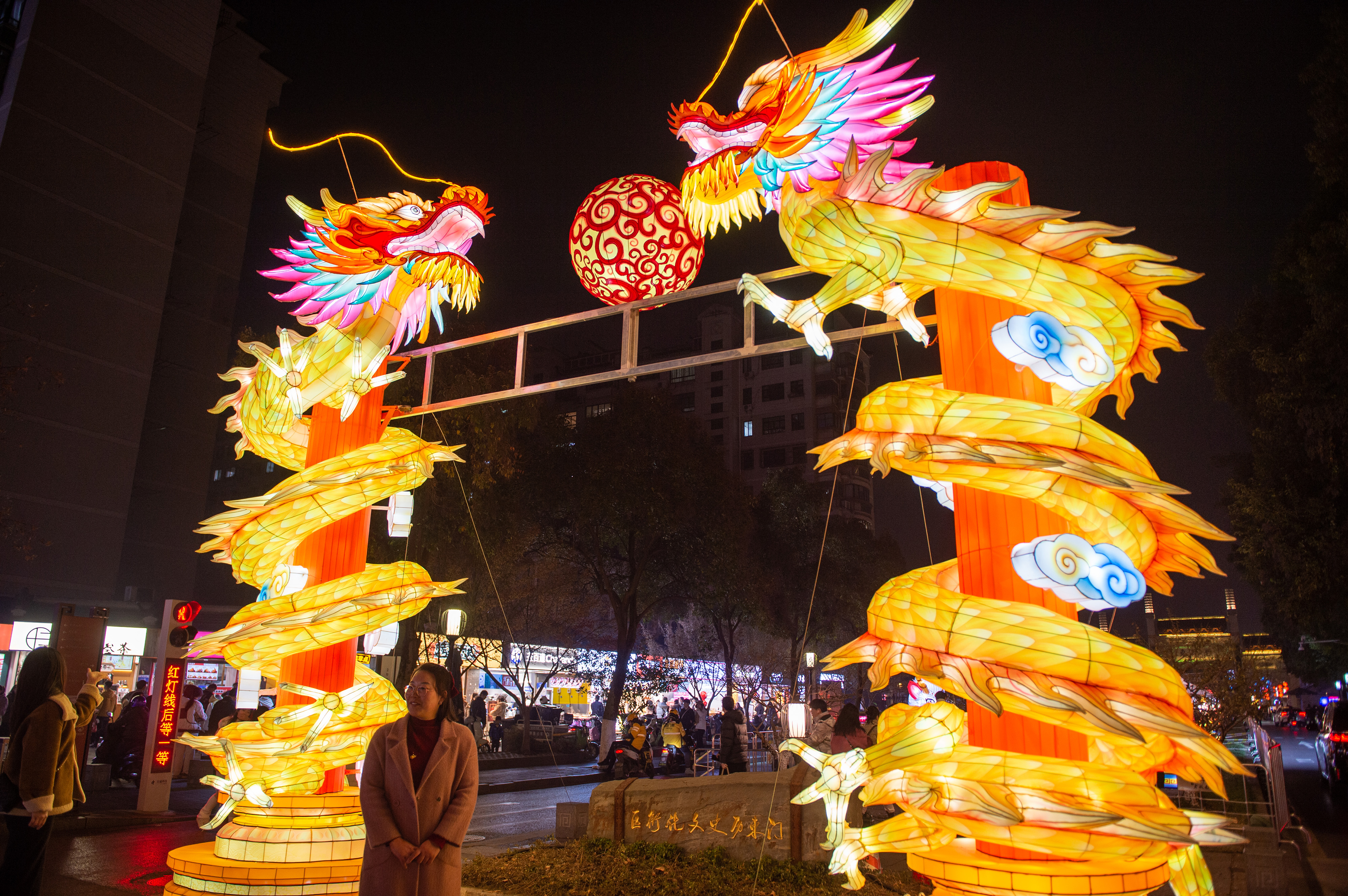 Two dragon-shaped lanterns are entwined around columns at Laomendong historical district in Nanjing, east China's Jiangsu Province on December 27, 2023./IC