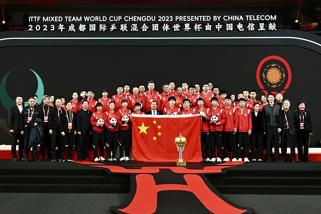 中国队于2023年12月10日在中国成都赢得首届国际乒联混合团体世界杯后举起国旗和奖杯庆祝。/CFP 