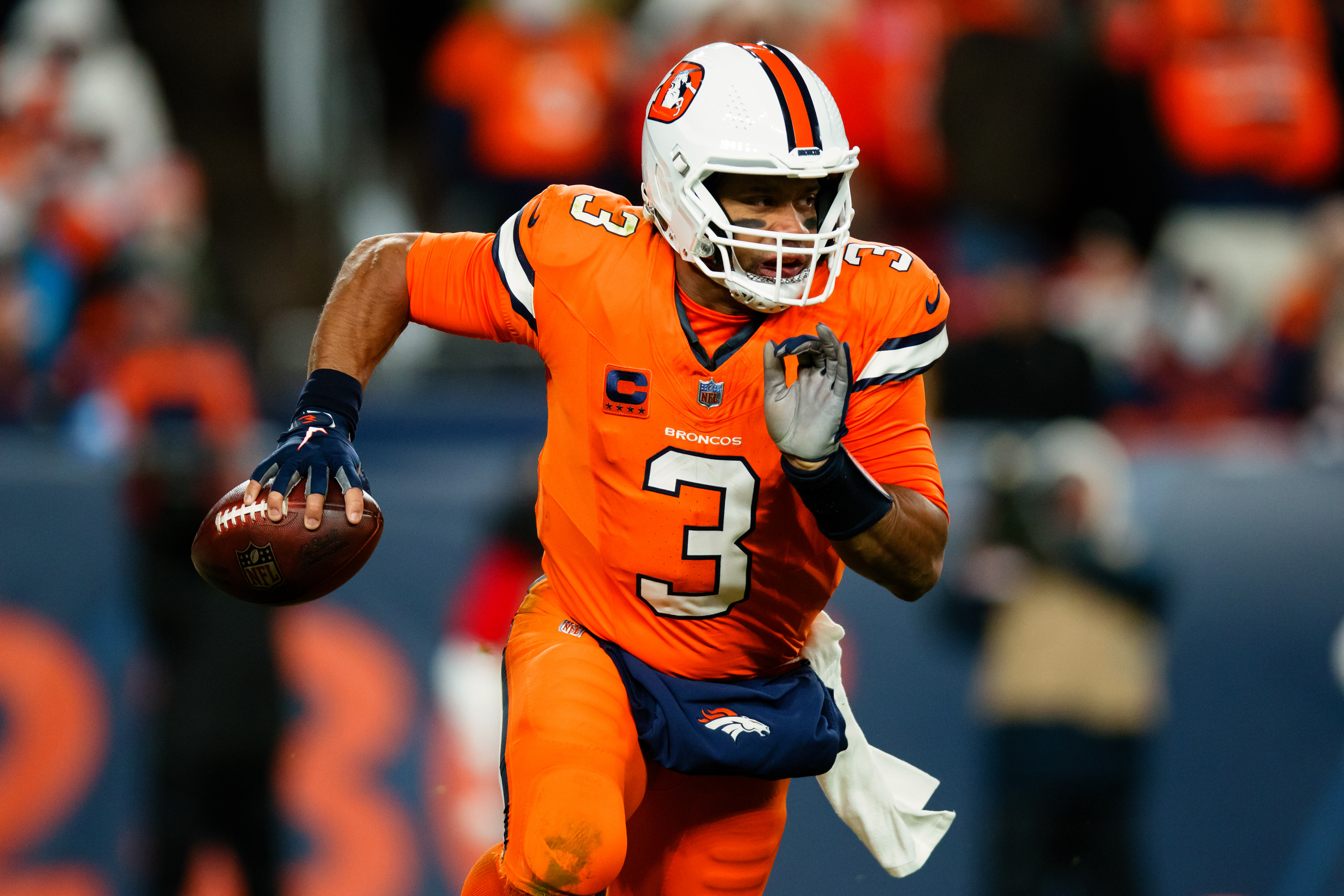 Quarterback Russell Wilson of the Denver Broncos runs with the ball in the game against the New England Patriots at Empower Field at Mile High in Denver, Colorado, December 24, 2023. /CFP 