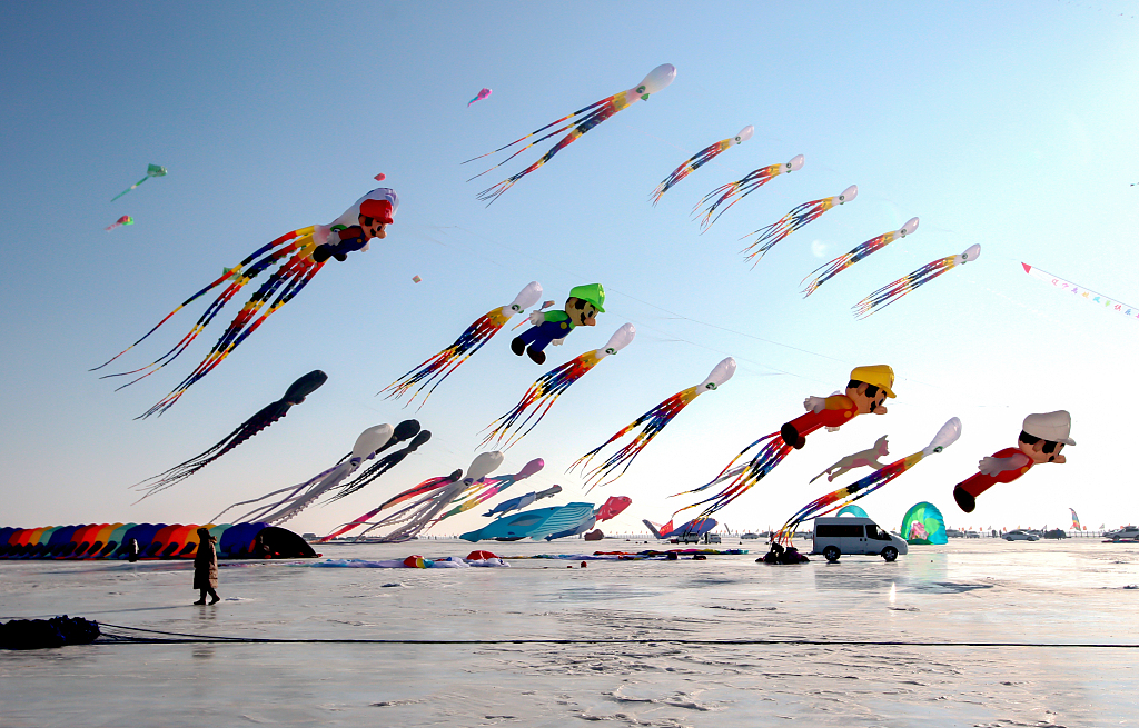Giant kites shaped like octopuses, whales, and Super Mario characters float in the sky to celebrate a bountiful fishing season at Chagan Lake, northeast China's Jilin Province on December 28, 2023. /CFP
