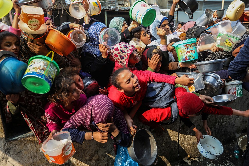 Palestinians queue for food that is cooked in large pots and distributed for free, December 28, 2023, Rafah, Gaza. /CFP
