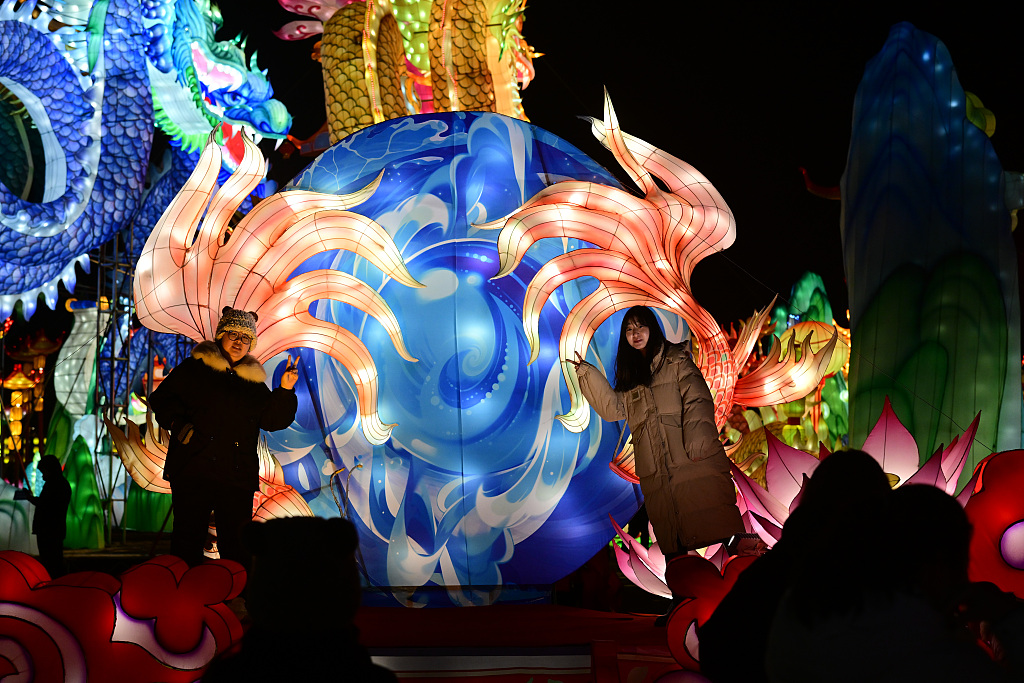 People take photos near giant luminous installations that decorate Guandong Movie and TV Town in Shenyang, Liaoning Province, on December 29, 2023. /CFP