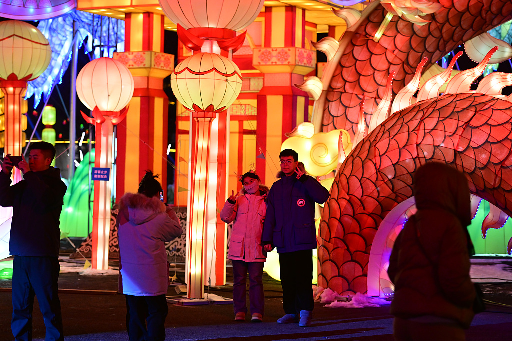 People take photos near giant luminous installations that decorate Guandong Movie and TV Town in Shenyang, Liaoning Province, on December 29, 2023. /CFP