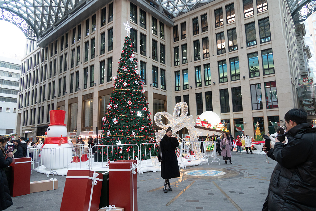 People take photos at the entrance to a market event at the Bund Central Square in Shanghai, east China, December 22, 2023. /CFP