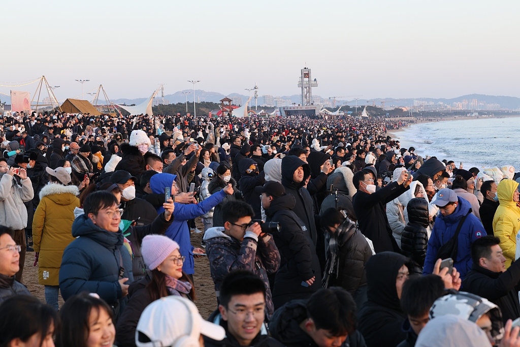 People enjoy the first sunrise of 2024 at the Wanpingkou scenic area in Rizhao, east China's Shandong Province, on January 1, 2024. /CFP