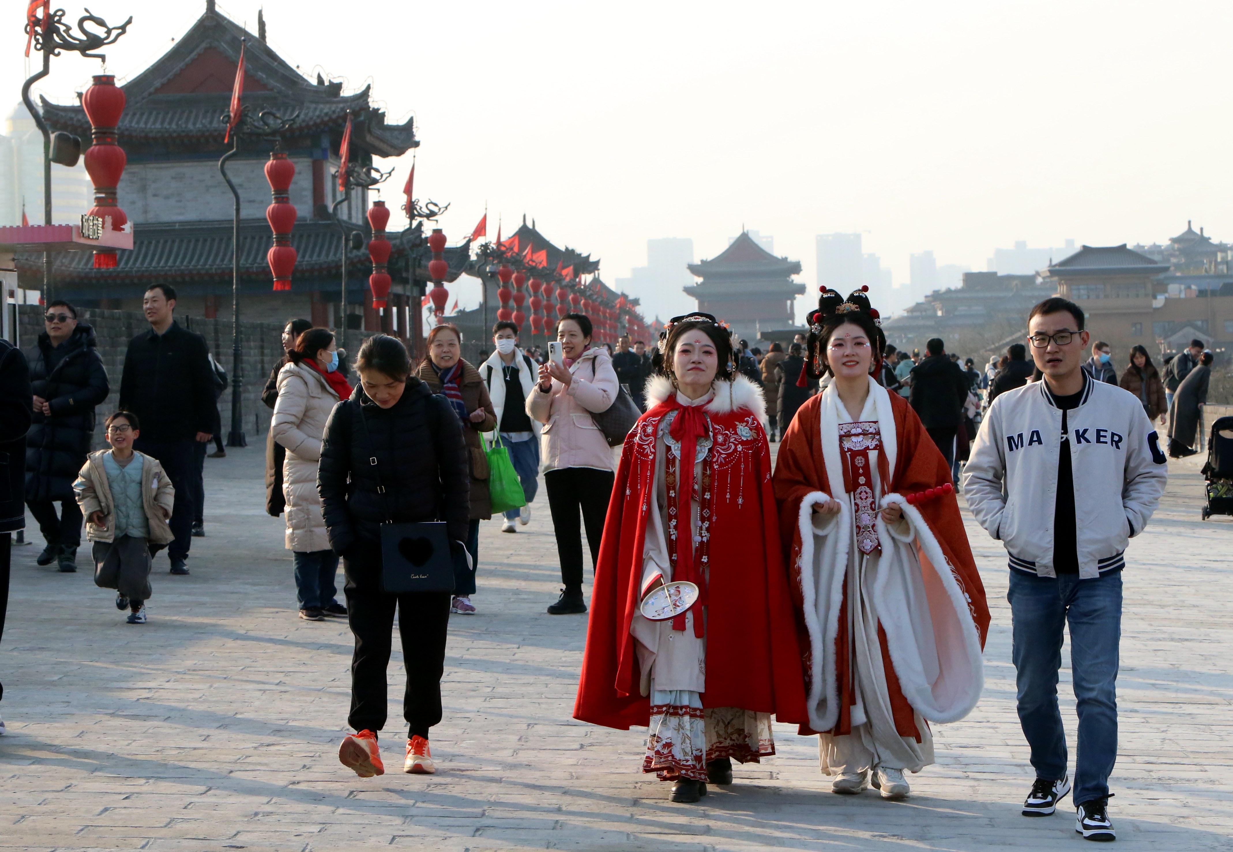 Visitors stroll along the ancient city wall of Xi'an in northwest China's Shaanxi Province on December 23, 2023. /IC