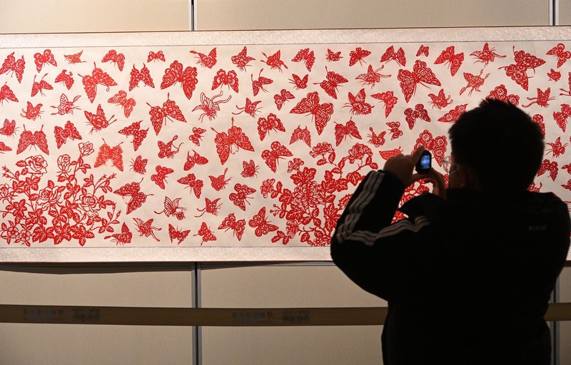 2024年1月1日，游客在河北省邯郸市博物馆拍摄蝴蝶剪纸壁画。/IC