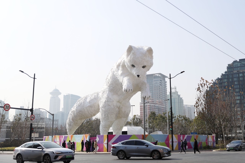 A photo shows cars passing an Arctic fox installation on a street corner in Shanghai on January 2, 2024. /IC