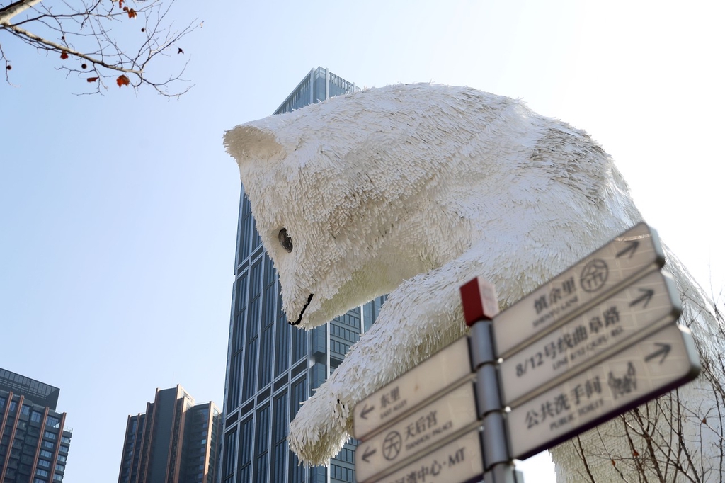 A photo shows street signs below an Arctic fox installation on a street corner in Shanghai on January 2, 2024. /IC