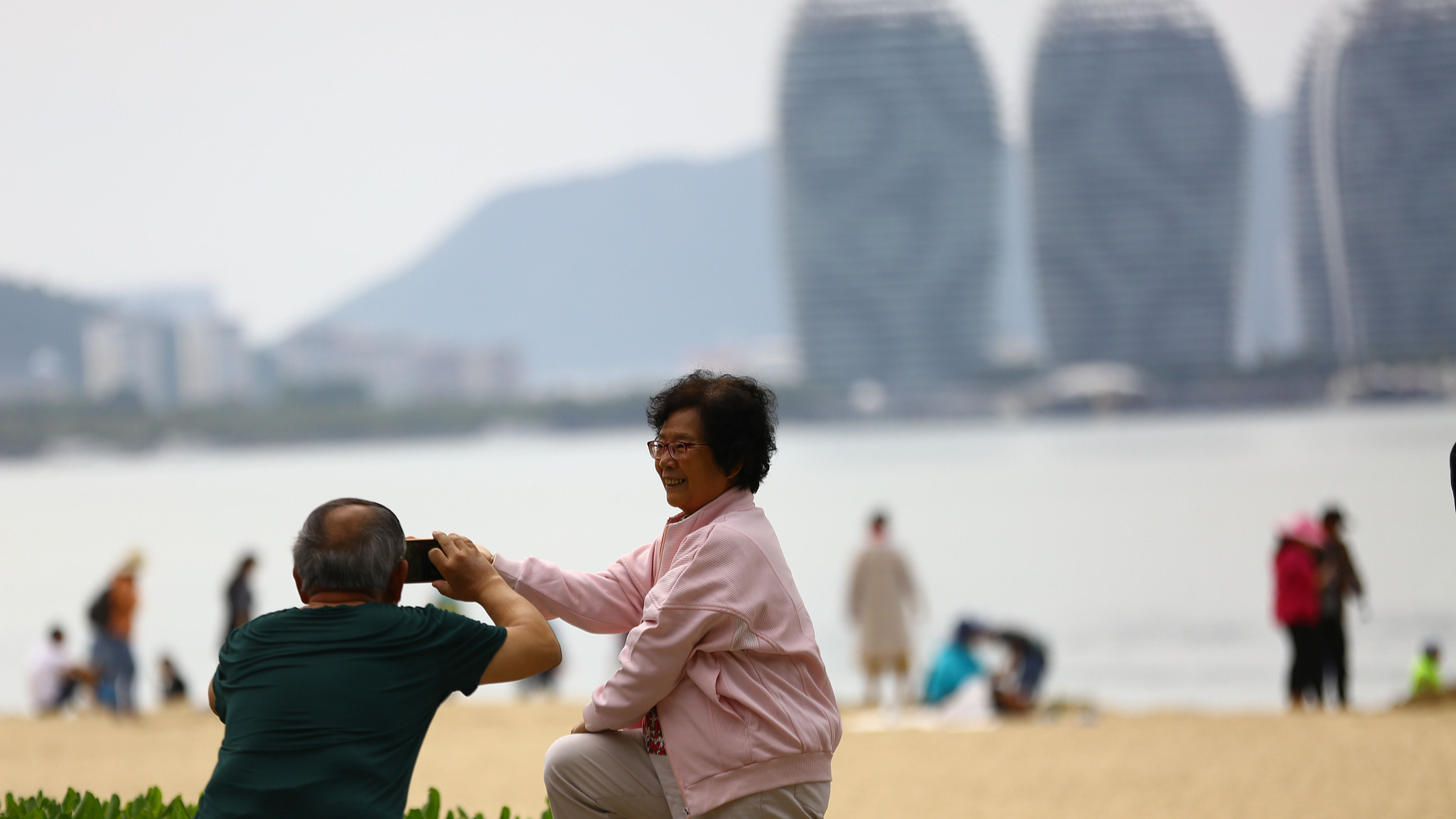 Seniors enjoy leisurely moments and take photos on the beach of Sanya Bay in South China's Hainan Province. /CFP