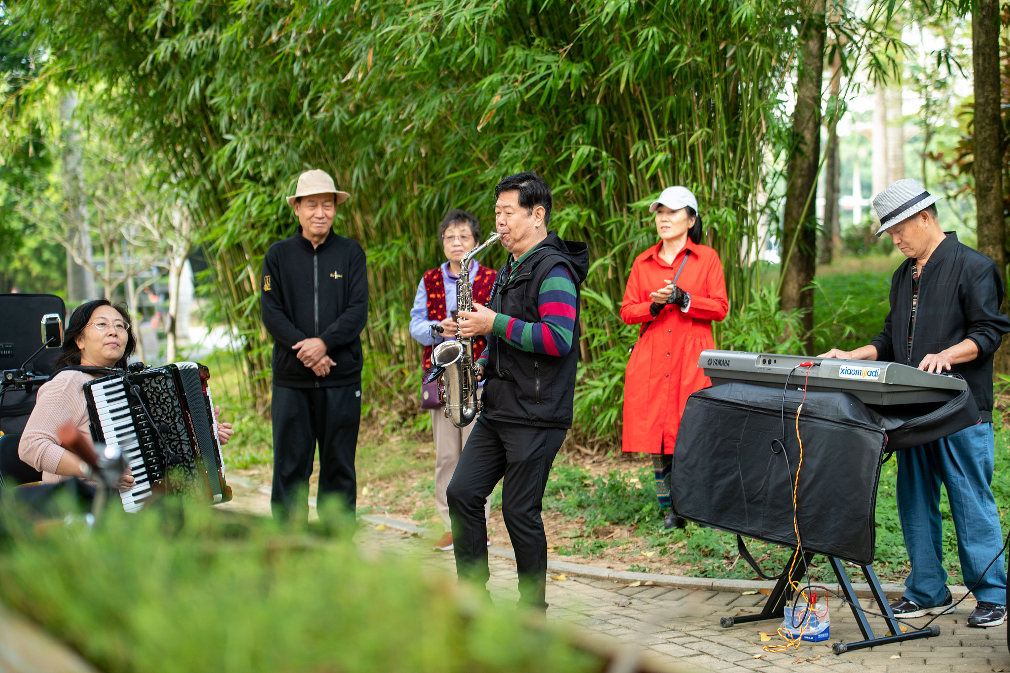 Seniors engage in musical entertainment by the riverside of Wanquan River in Qionghai City, South China's Hainan Province. /CFP