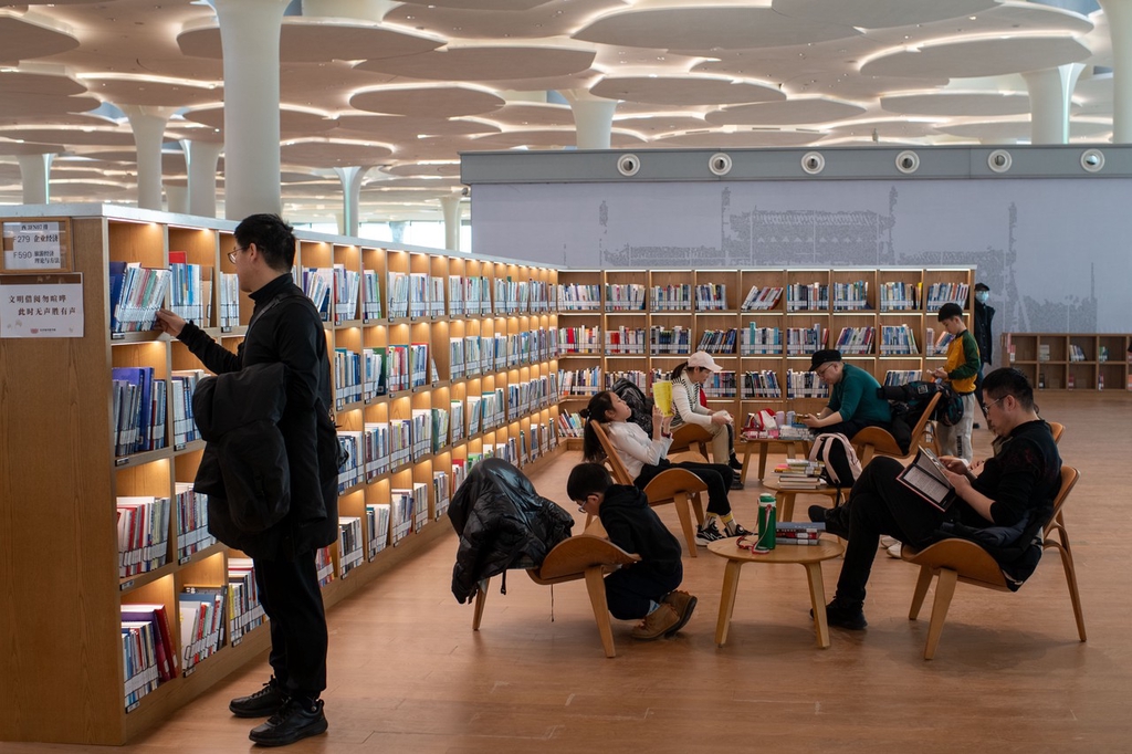 A photo shows visitors browsing through books at the new Beijing City Library in Beijing on January 1, 2024. /IC