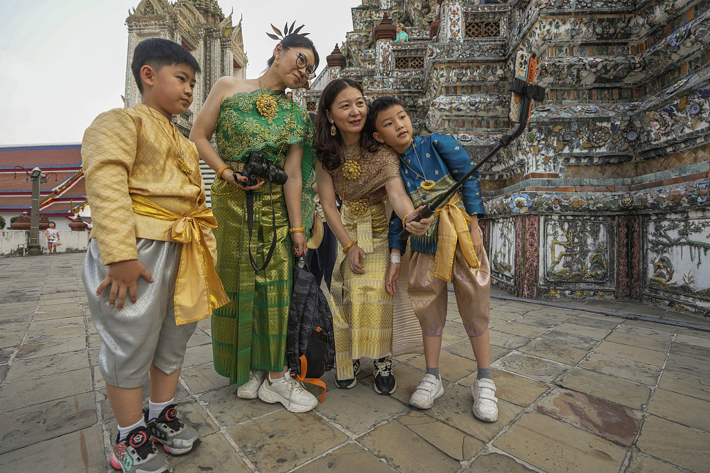 A file photo shows Chinese tourists dressed in traditional Thai costumes taking a selfie at the Wat Arun temple in Bangkok, Thailand on January 12, 2023. /CFP