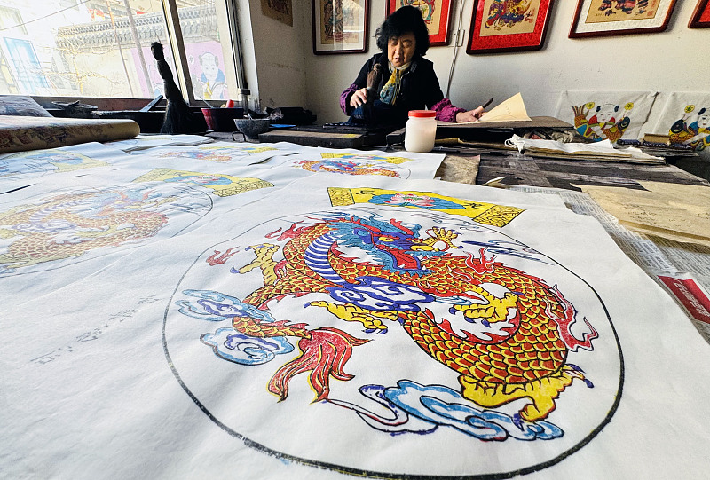 An artist creates traditional woodblock New Year paintings at a workshop in Yangjiabu Village in Weifang, Shandong Province on January 3, 2024. /CFP