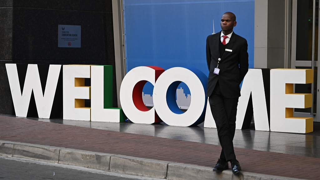 A man stands near a welcome sign outside the venue of the BRICS summit in Johannesburg, South Africa, August 20, 2023. /CFP