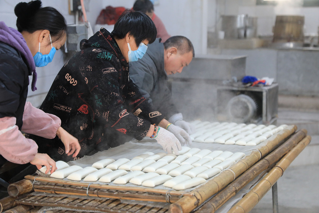 Photo taken on January 3, 2024 shows villagers making rice cakes in a small workshop in Zhoushan, Zhejiang Province. /CFP