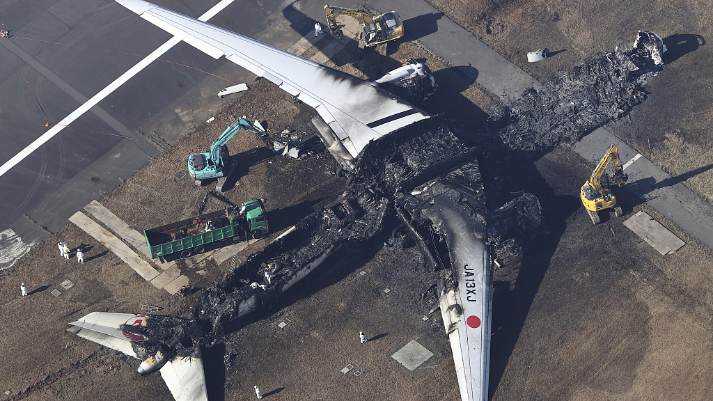An aerial photo shows a removing work of a burned Japan Airlines Airbus A350 plane remains on the runway at Haneda Airport in Tokyo, Japan, January 5, 2024. /CFP