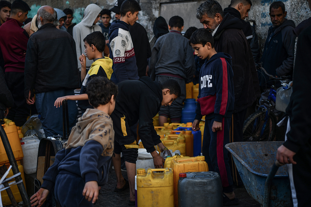 Palestinians wait in line to get clean water from a fountain, Gaza, January 3, 2024. /CFP