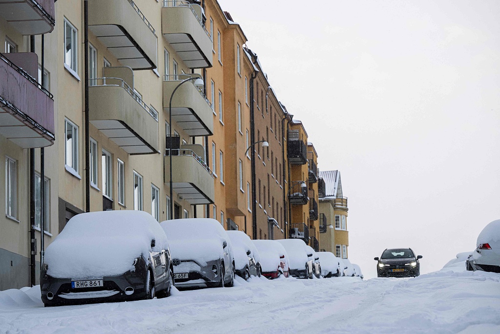 A man cleans off the snow from his car in Sundbyberg, near Stockholm in Sweden, January 4, 2024. /CFP