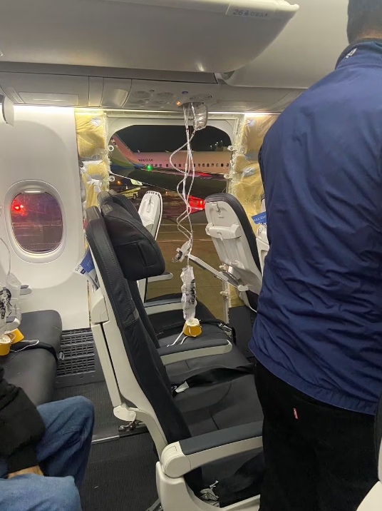 Passenger oxygen masks hang from the roof next to a missing window and a portion of a side wall of Alaska Airlines Flight 1282, which had been bound for Ontario, California, and suffered depressurization soon after departing, Portland, Oregon, U.S., January 5, 2024 in this picture obtained from social media. /Reuters