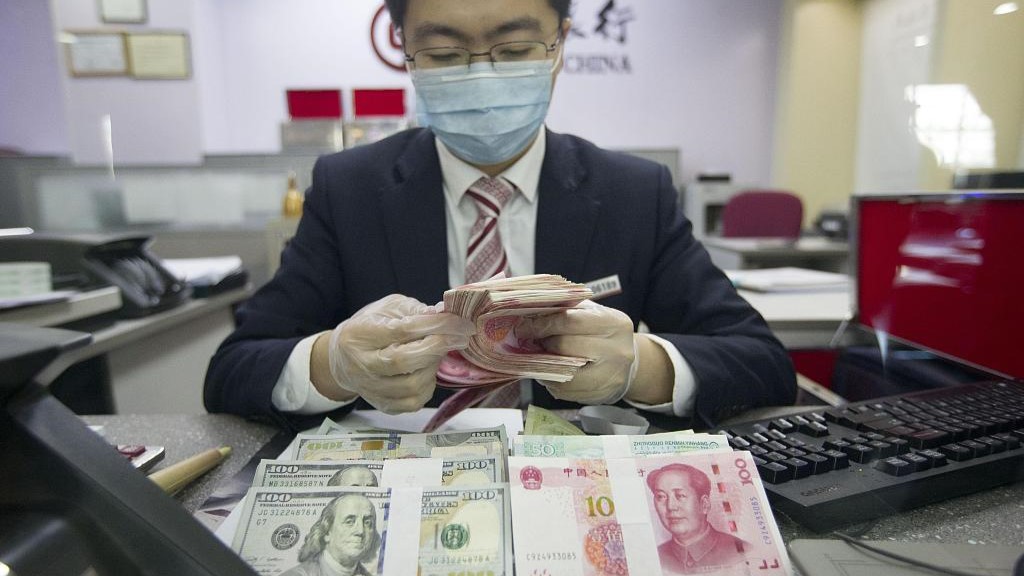 A bank employee is counting currency in north China's Shanxi Province, March 13, 2020. /CFP