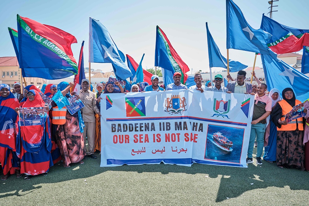 People hold banners and flags during a demonstration in support of Somalia's government following the port deal signed between Ethiopia and the breakaway region of Somaliland at Eng Yariisow Stadium in Mogadishu, January 3, 2024. /CFP