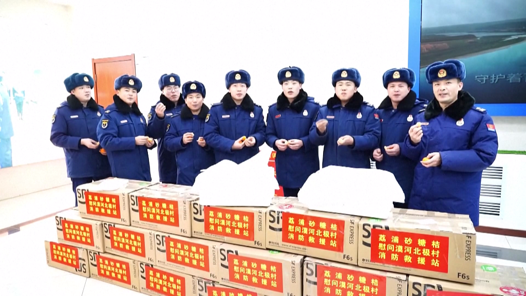 Firefighters at Beiji Village in Mohe, Heilongjiang Province receive honey mandarins from Lipu, Guangxi Zhuang Autonomous Region, on January 7, 2024. /CFP