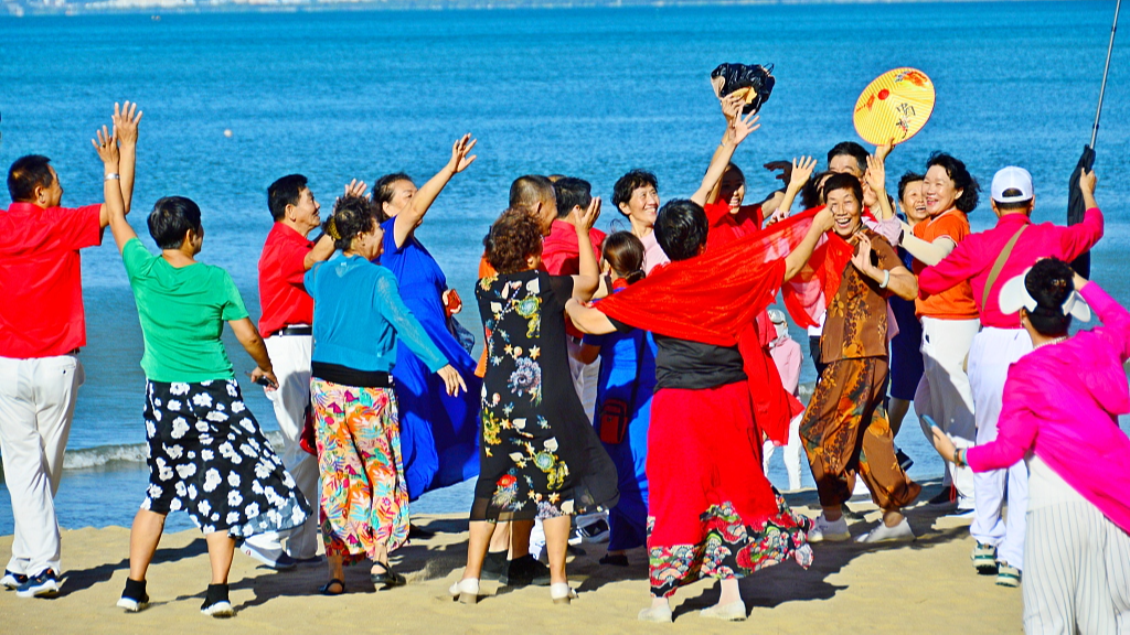 Elderly people dance and take photos at the beach in Sanya, south China's Hainan Province, December 17, 2023. /CFP