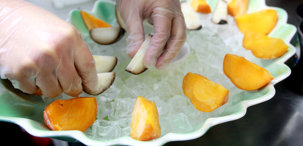 A chef makes a frozen fruit platter at a restaurant in Harbin on January 9, 2024. /CFP