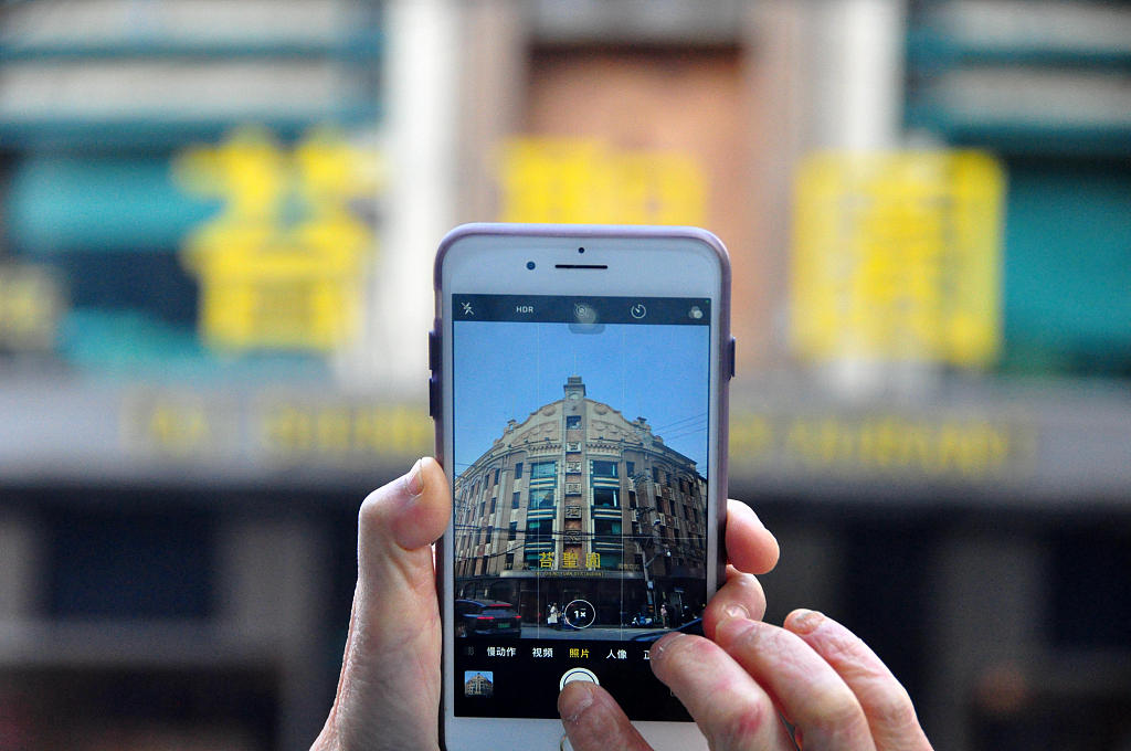 A photo taken on January 7, 2024 shows a visitor taking photos of the Zhi Zhen Yuan restaurant in Shanghai, China. /CFP