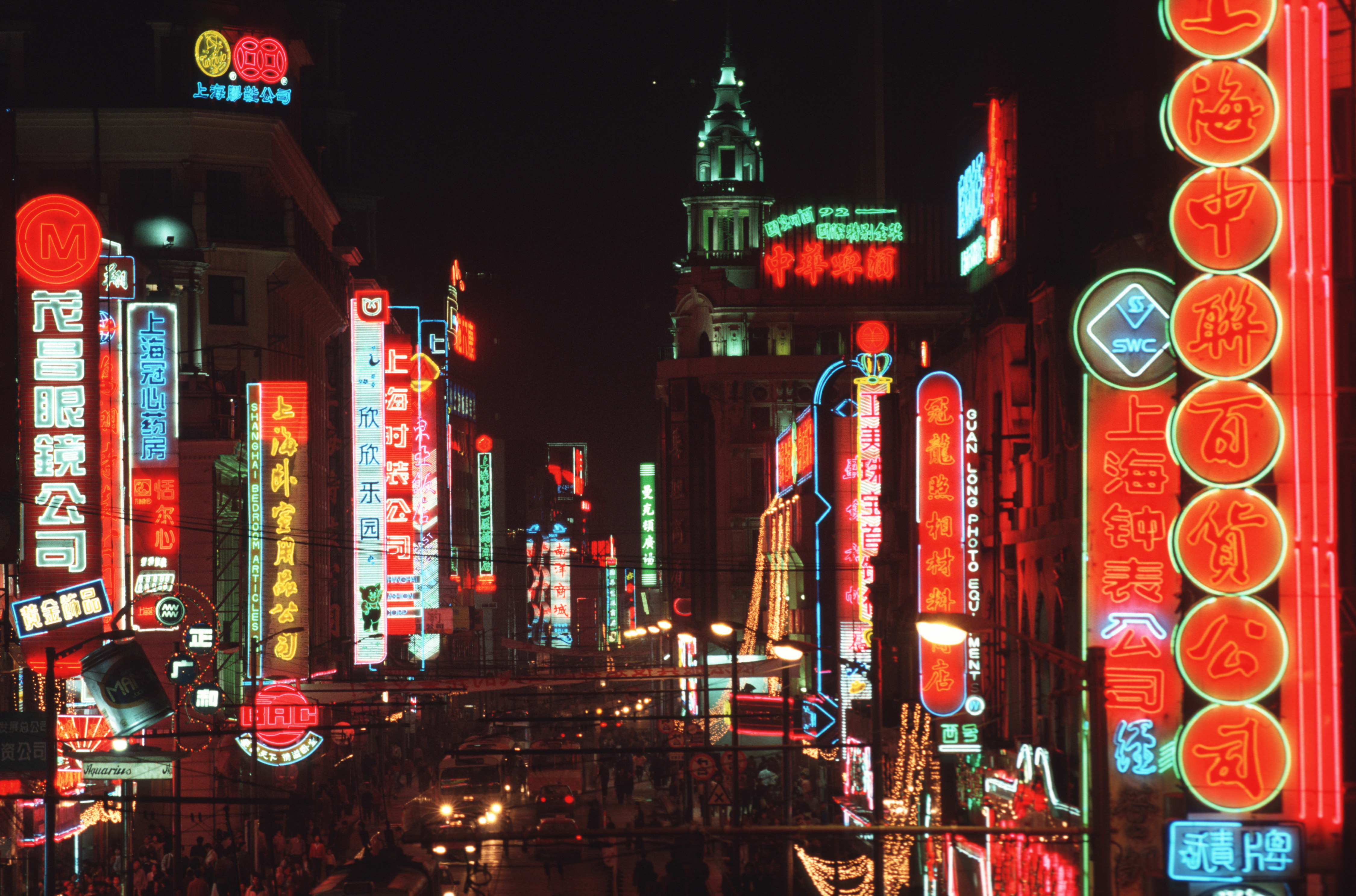 Neon advertising signs light up Nanjing Road as cars, traffic and pedestrians crowd one of Shanghai's busiest thoroughfares and shopping areas, China, November 1, 1993. /CFP