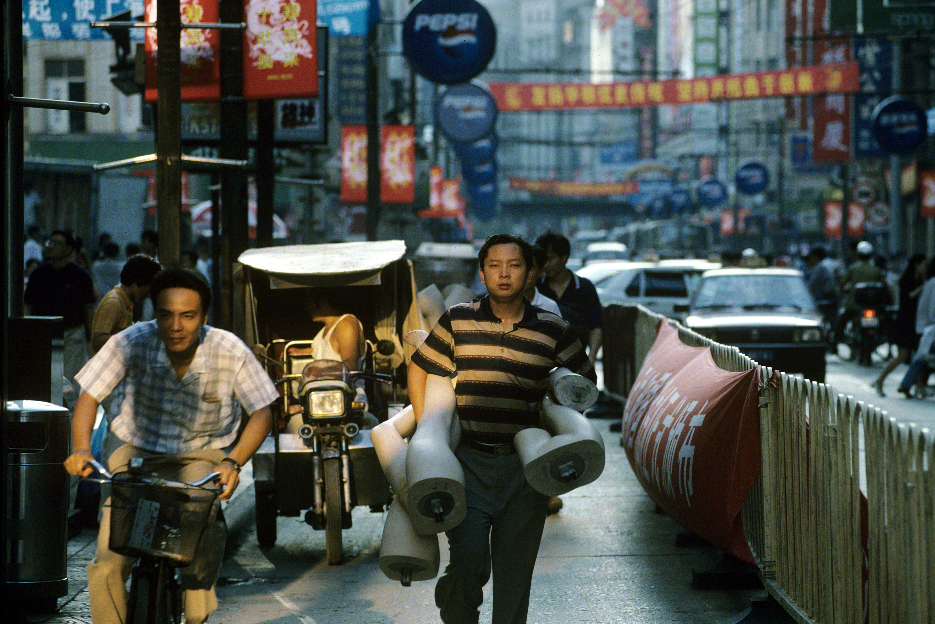 A street with people, signs and traffic in Shanghai, China, October 1998. /CFP 