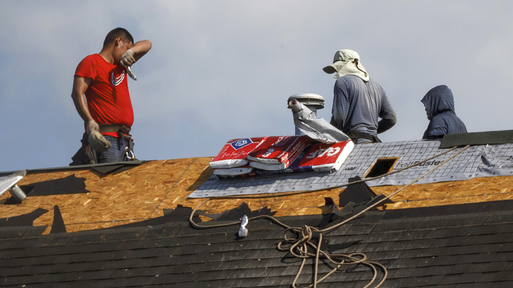 A worker wipes his face when installing new roof on a home in Frederick, Maryland, U.S., July 24, 2023. /CFP