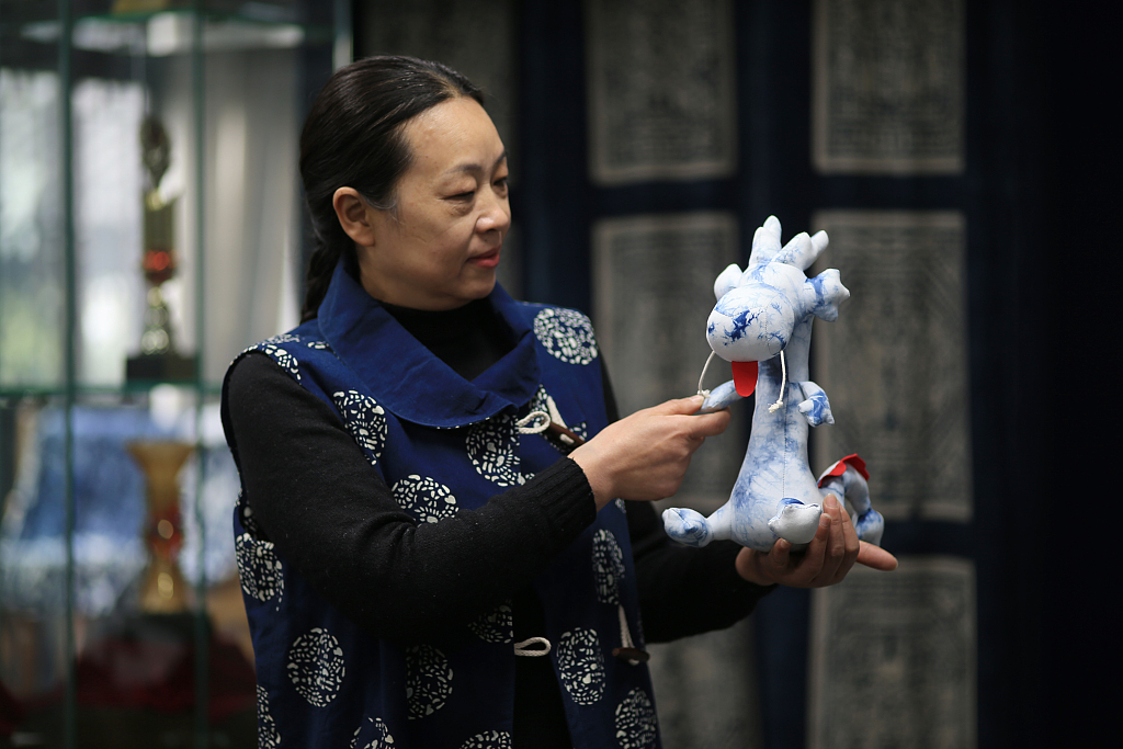 Photo taken on January 10, 2024 shows traditional craft master Wu Lingshu holding a blue calico 