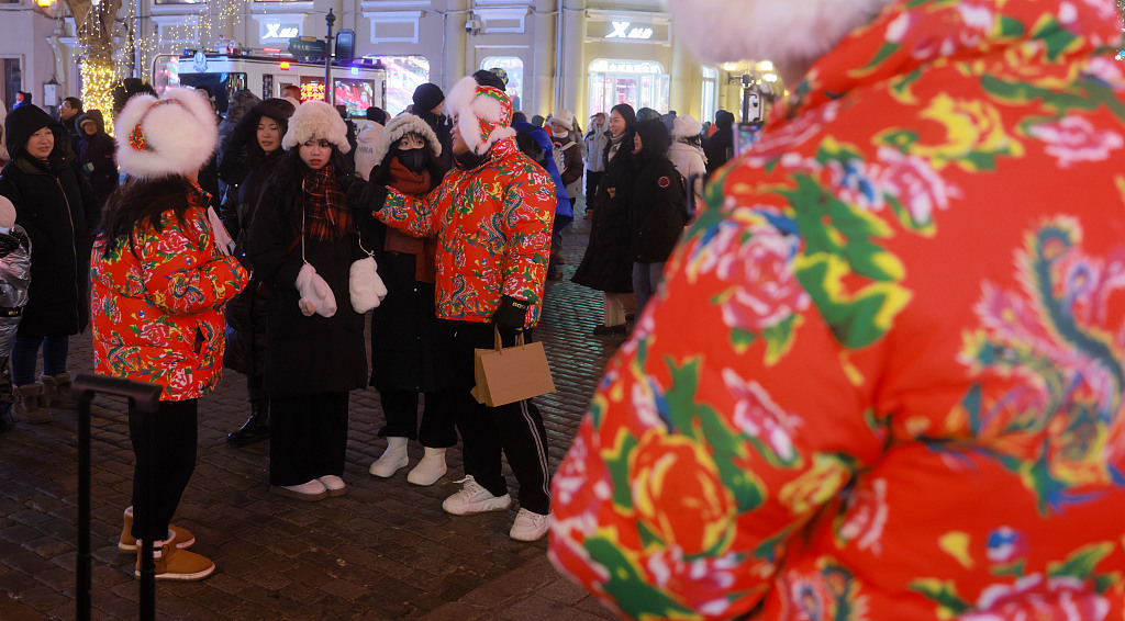 Photo taken on January 9, 2024 shows traditional flower patterns are popular among tourists in Harbin, Heilongjiang Province. People are seen wearing the patterns across Harbin's various tourist sites. /CFP