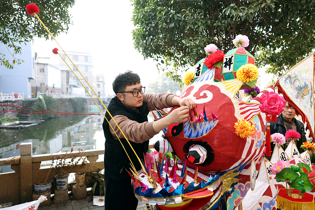 Photo taken on January 10, 2024 shows a craftsman in Dongyang, Zhejiang Province, working on a dragon head, adding a touch of tradition and festivity to the atmosphere as Spring Festival approaches. /CFP
