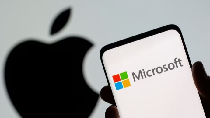 Microsoft logo is seen on the smartphone in front of displayed Apple logo. /Reuters