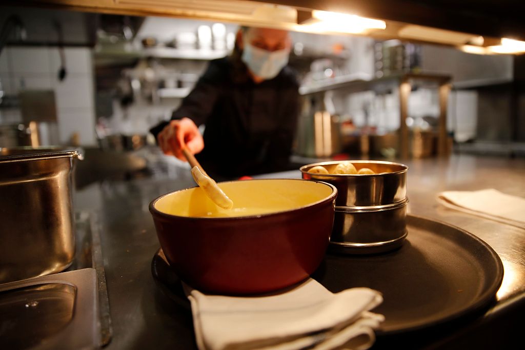 A file photo shows a cook preparing a fondue at a restaurant in Bern, Switzerland. /CFP