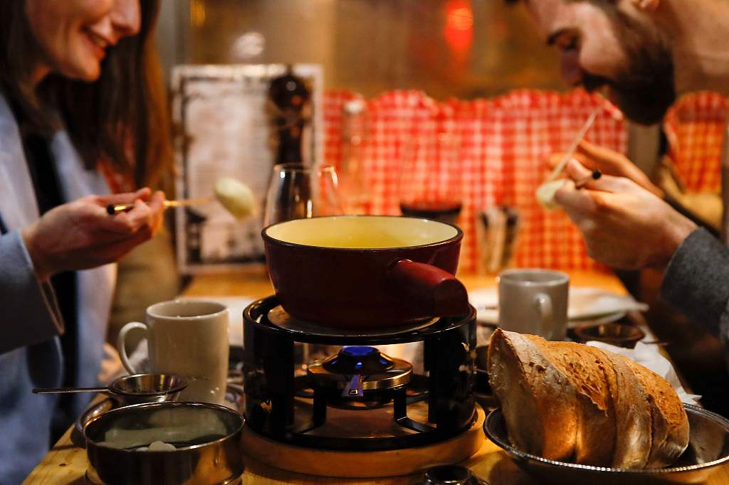 A file photo shows two diners enjoying a fondue at a restaurant in Bern, Switzerland. /CFP